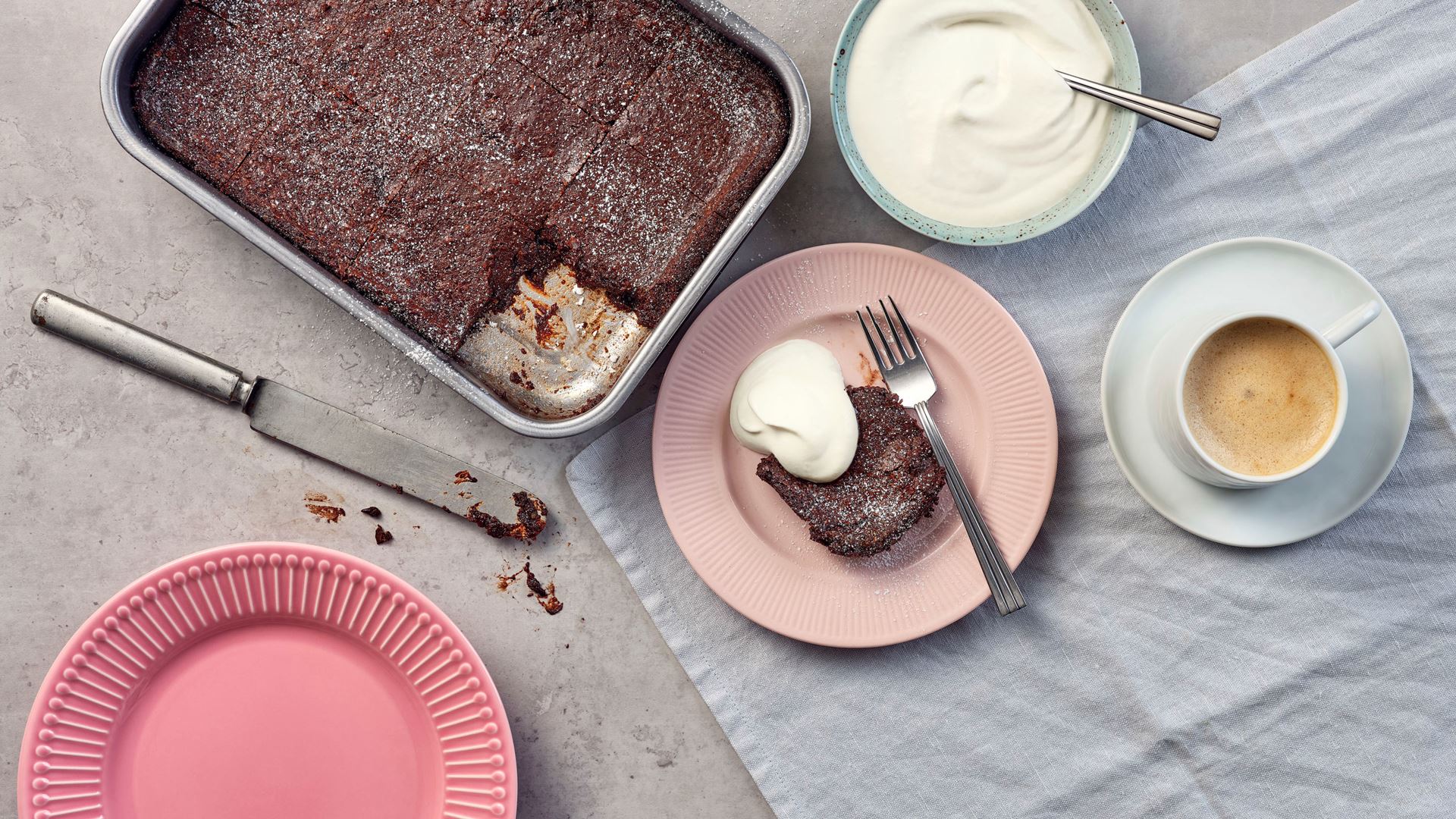 hasselnötsbrownie på tallrik och form med grädde