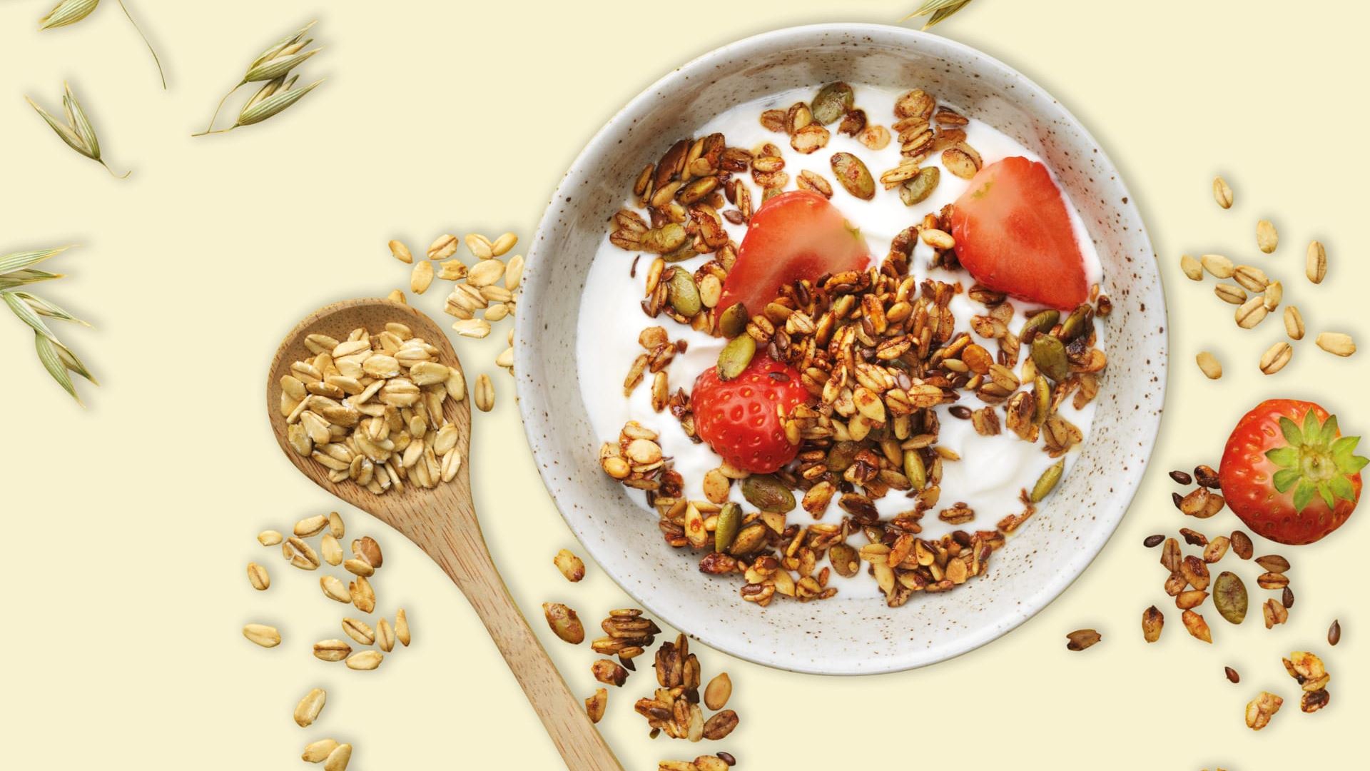 Tallrik med yoghurt toppad med frögranola och jordgubbar