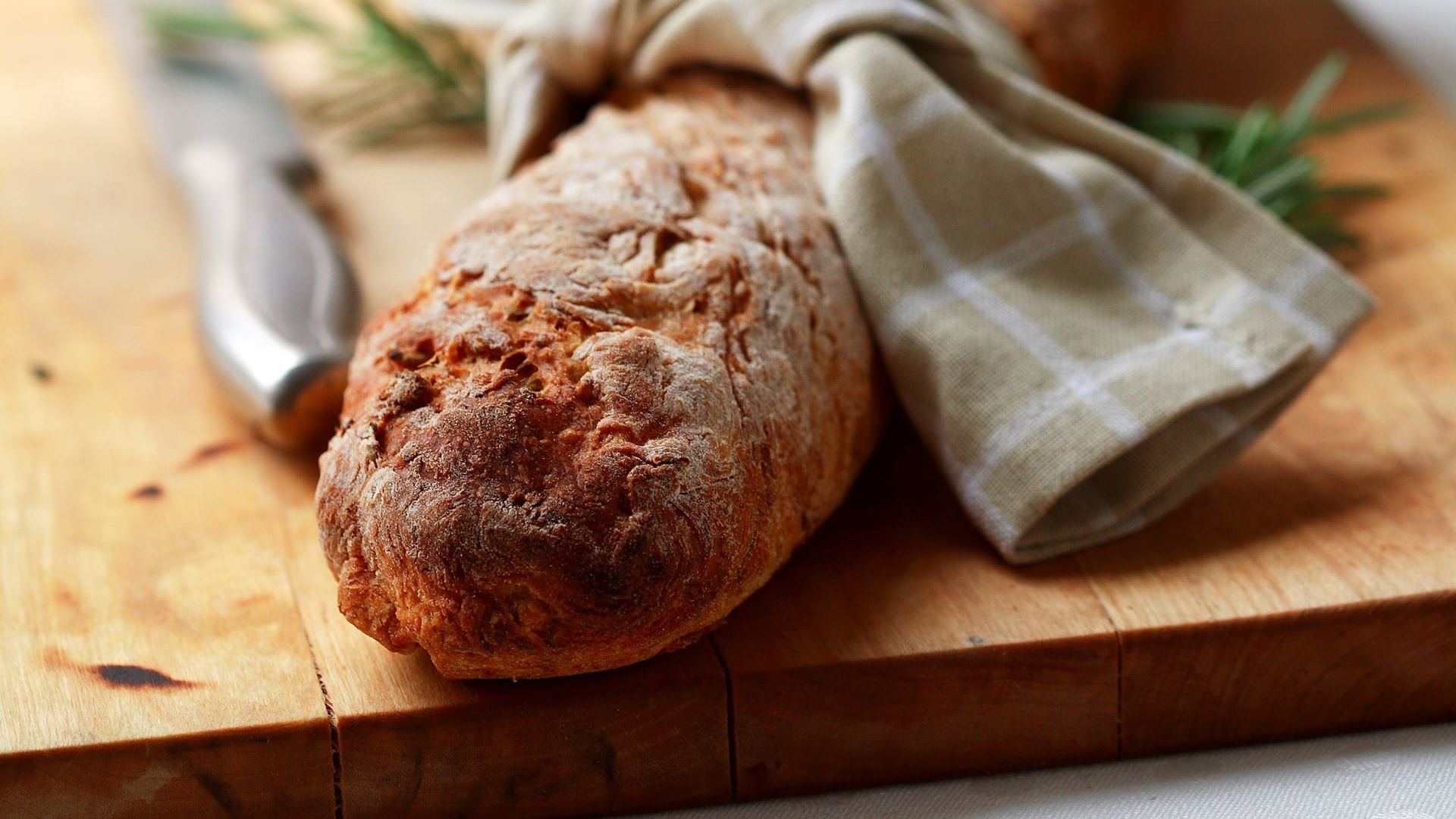 Morotsbaguette invirad i en kökshanduk på en skärbräda