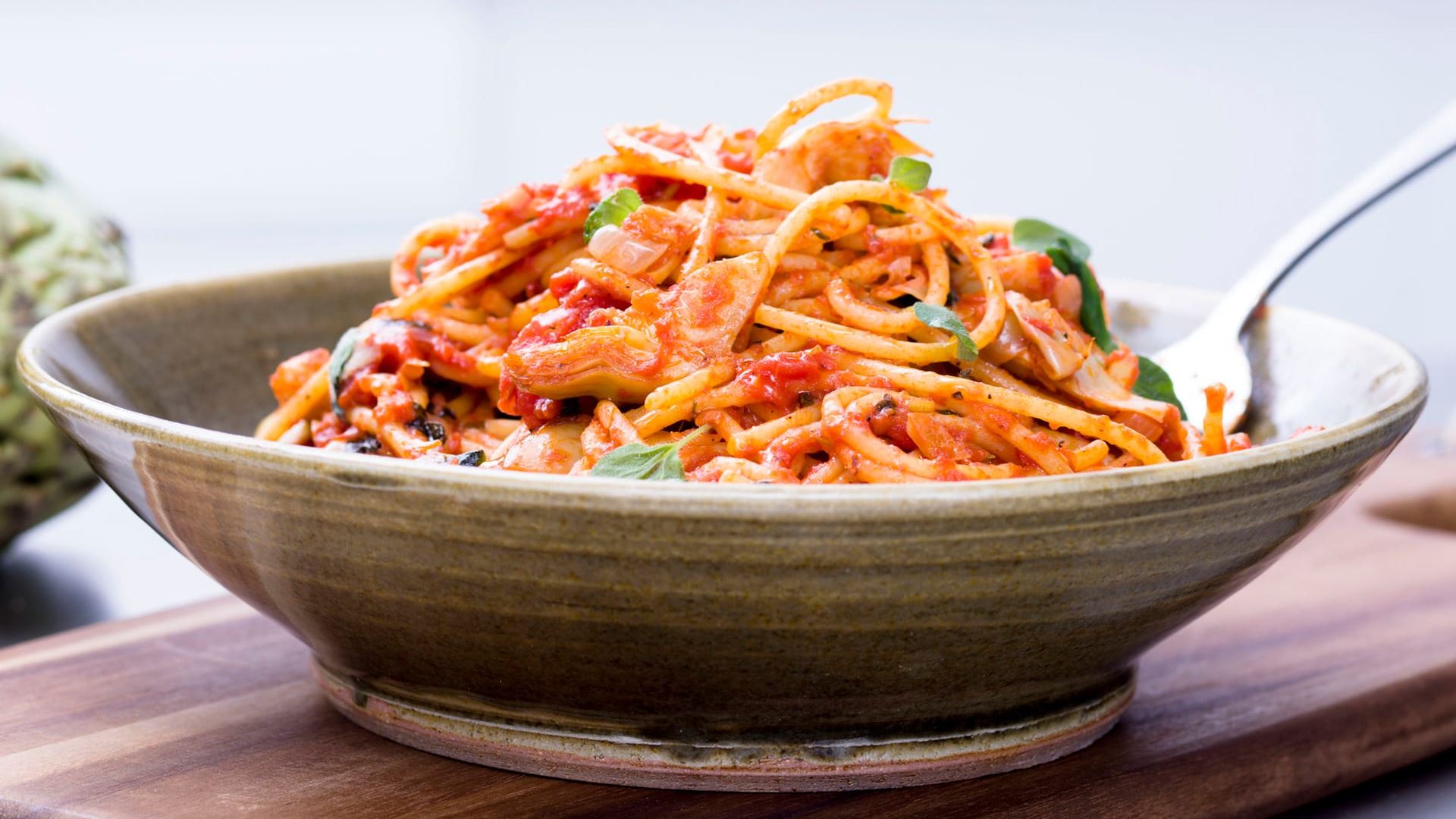 Tallrik med spaghetto med tomat och kronärtskockort