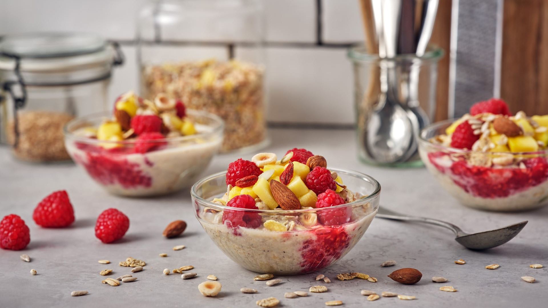 Overnight müsli i skålar toppade med hallon och mango