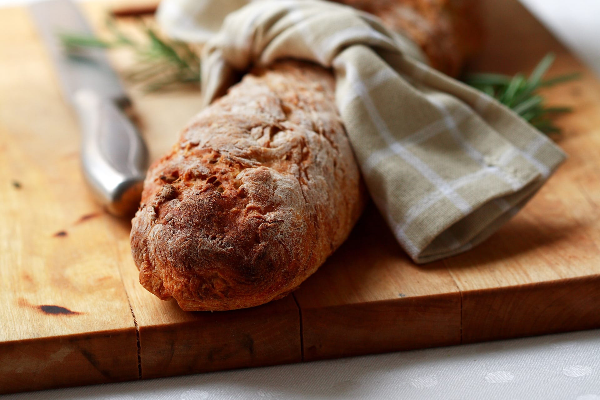 Morotsbaguette invirad i en kökshanduk på en skärbräda